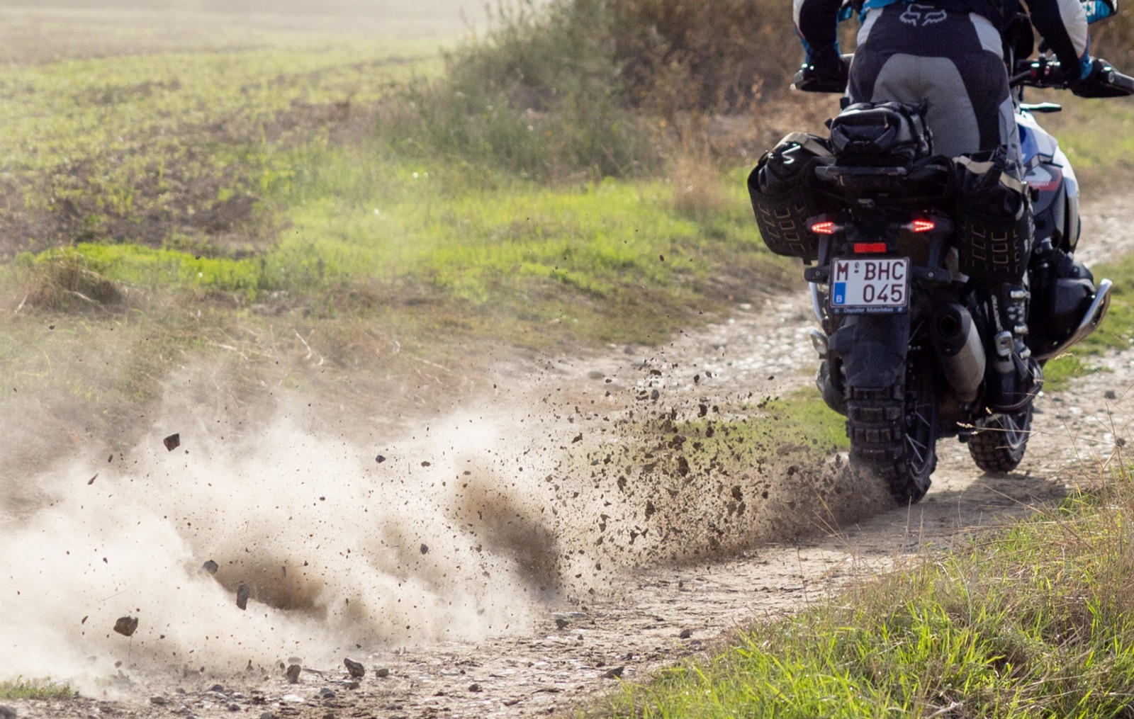 Poussière et gravier derrière une moto